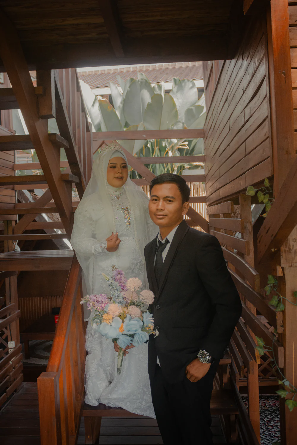 A bride in white and a groom in a dark suit standing together